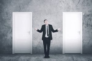 international school jobs Search Associates ANZ man in a suit standing in between two white doors