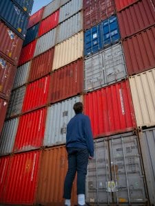 background checks for international schools Search Associates ANZ man staring up at a wall of shipping containers 