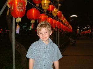 Succeeding in your new school Search Associates ANZ happy child in Hong Kong standing in front of shining red lanterns in the evening