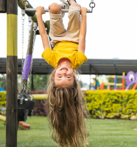 should I teach overseas with my family? Search Associates ANZ turn your life upside down like this happy girl in the playground