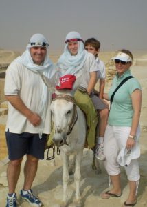 How are international schools different from other schools overseas?| Search Associates Australia New Zealand| Nick in the desert with his kids riding a donkey